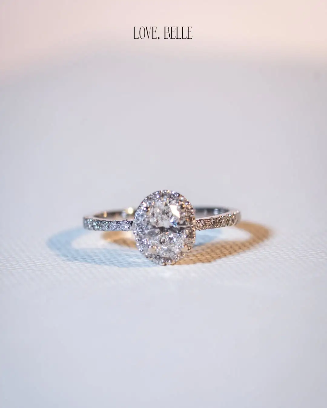 An oval-cut ring with a diamond halo